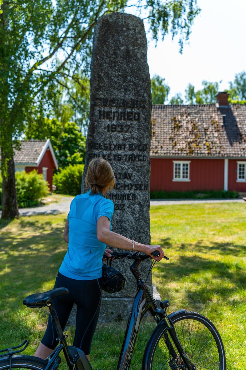 Syklist som har stoppet ved et monument