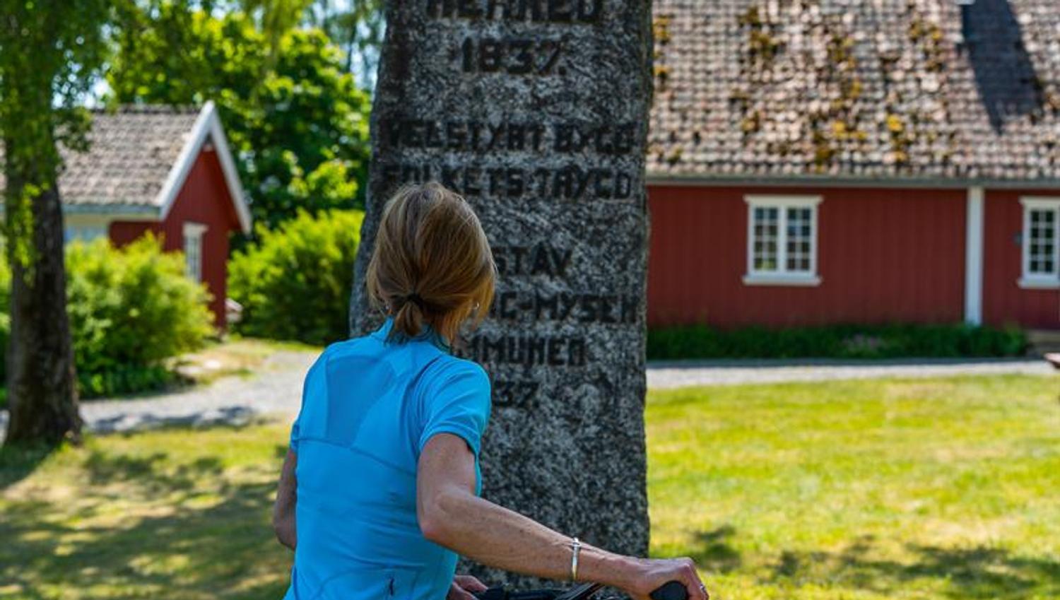 Syklist som har stoppet ved et monument