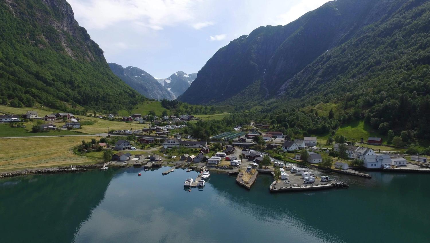 Panoramabilde av Sundal med fjord, bygda og breen som tronar mellom fjella i Hardanger.