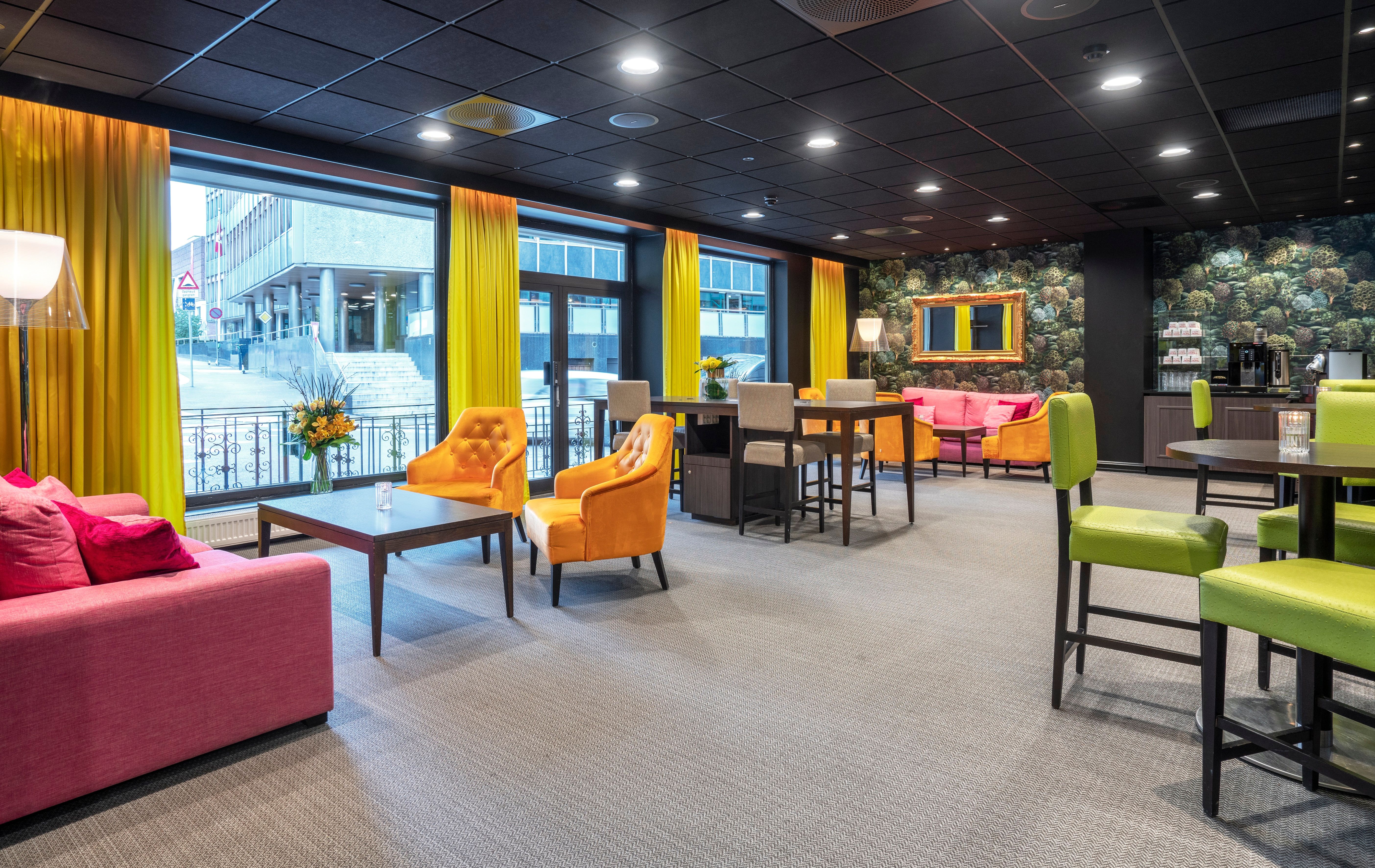 Lobby with sofas and chairs in red, green and orange. Yellow curtains. Thon Hotel Slottsparken, Oslo