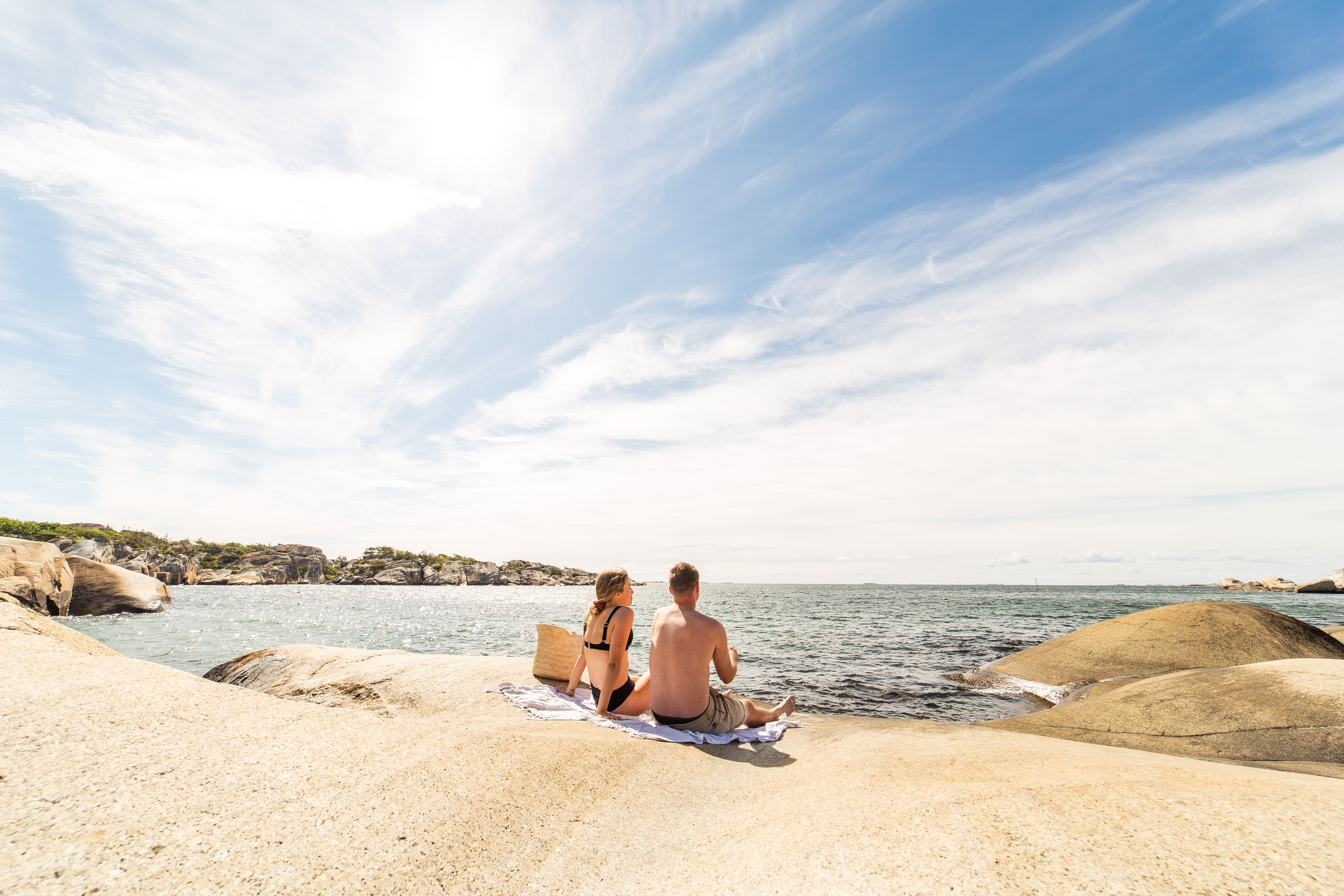 To mennesker sitter på svaberg på Ula badestrand