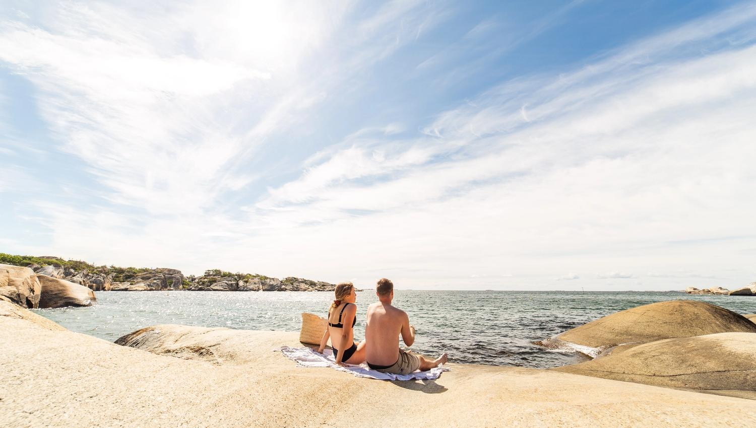 To mennesker sitter på svaberg på Ula badestrand