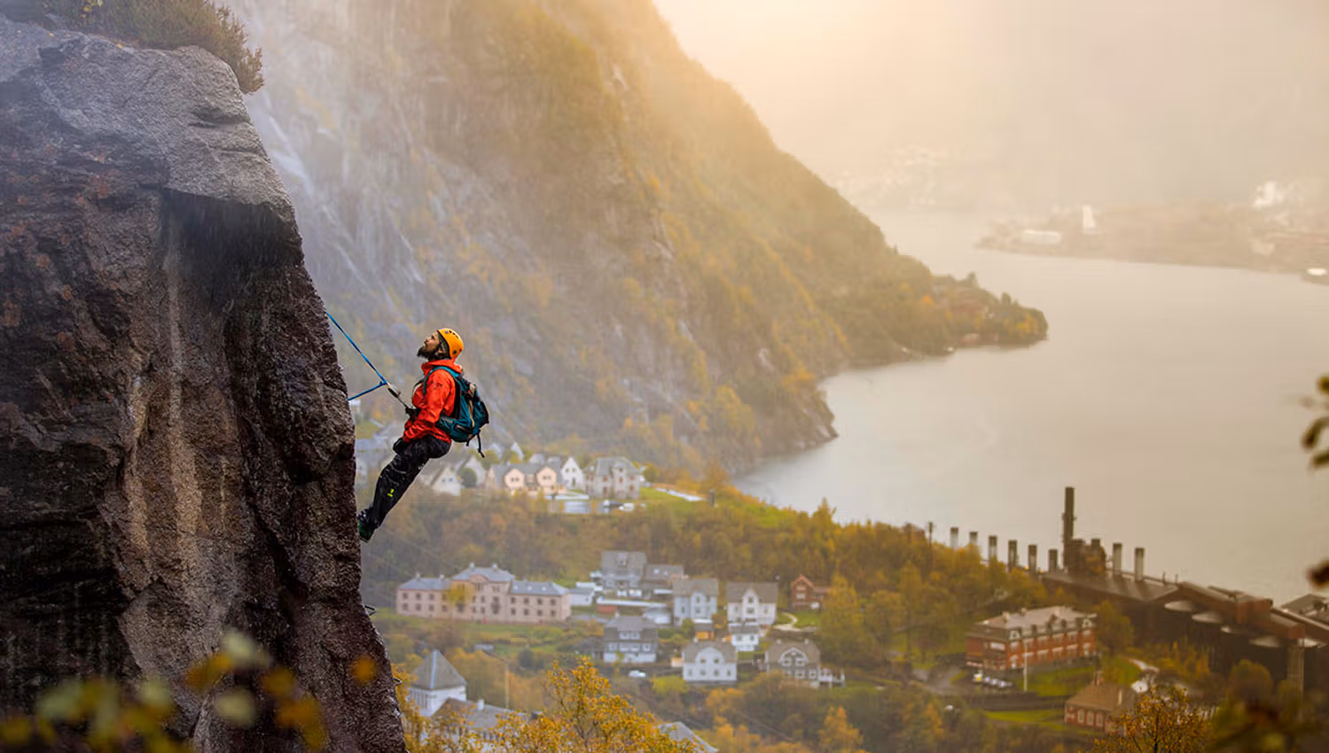 Climber on Via Ferrata Tyssedal with panoramic views over the Sørfjorden.