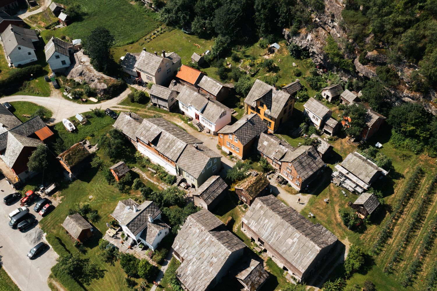 Drone photo of Agatunet with historic wooden houses clustered together, surrounded by green landscape and orchards.