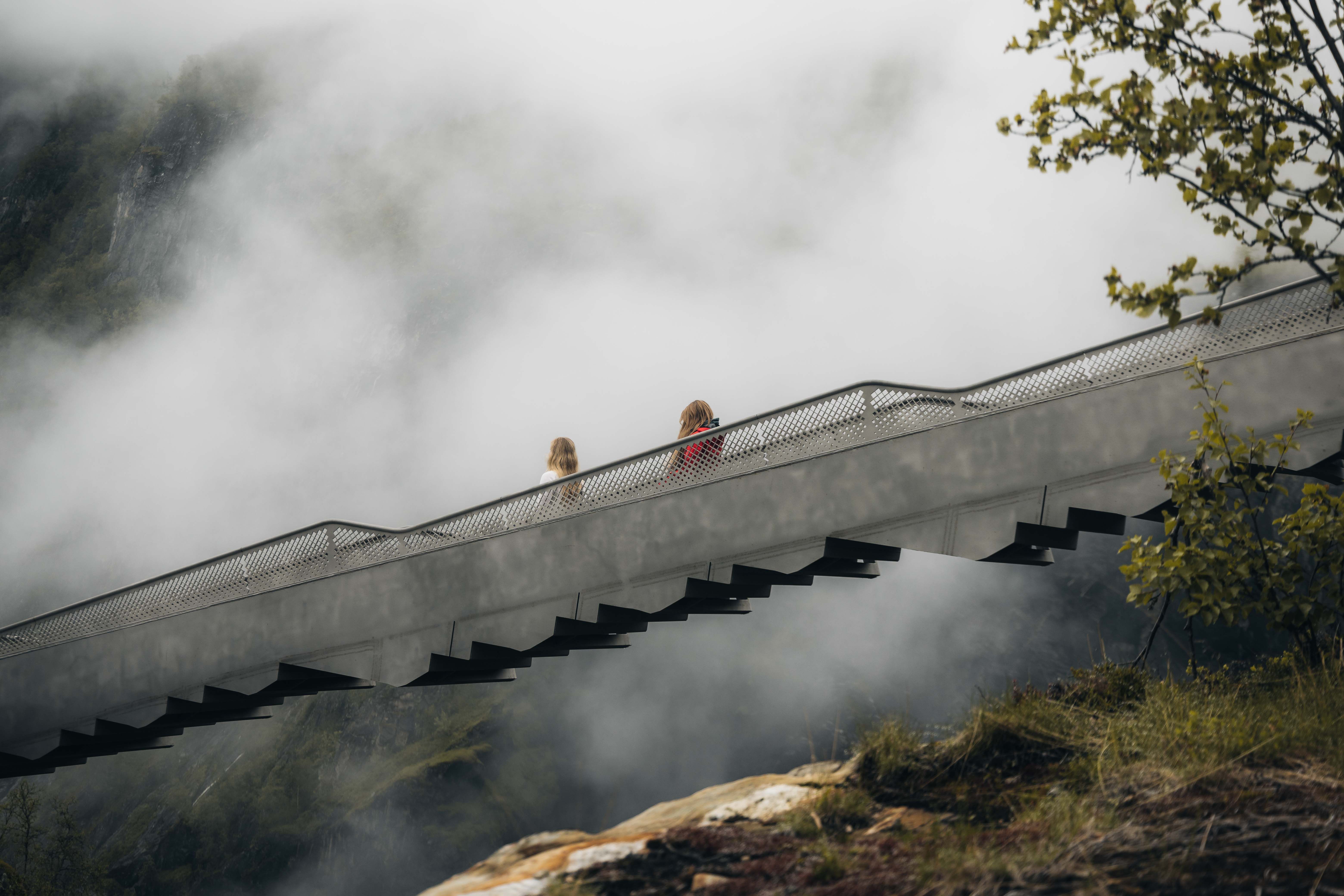 The step bridge seen from the side, with two women walking down the bridge.