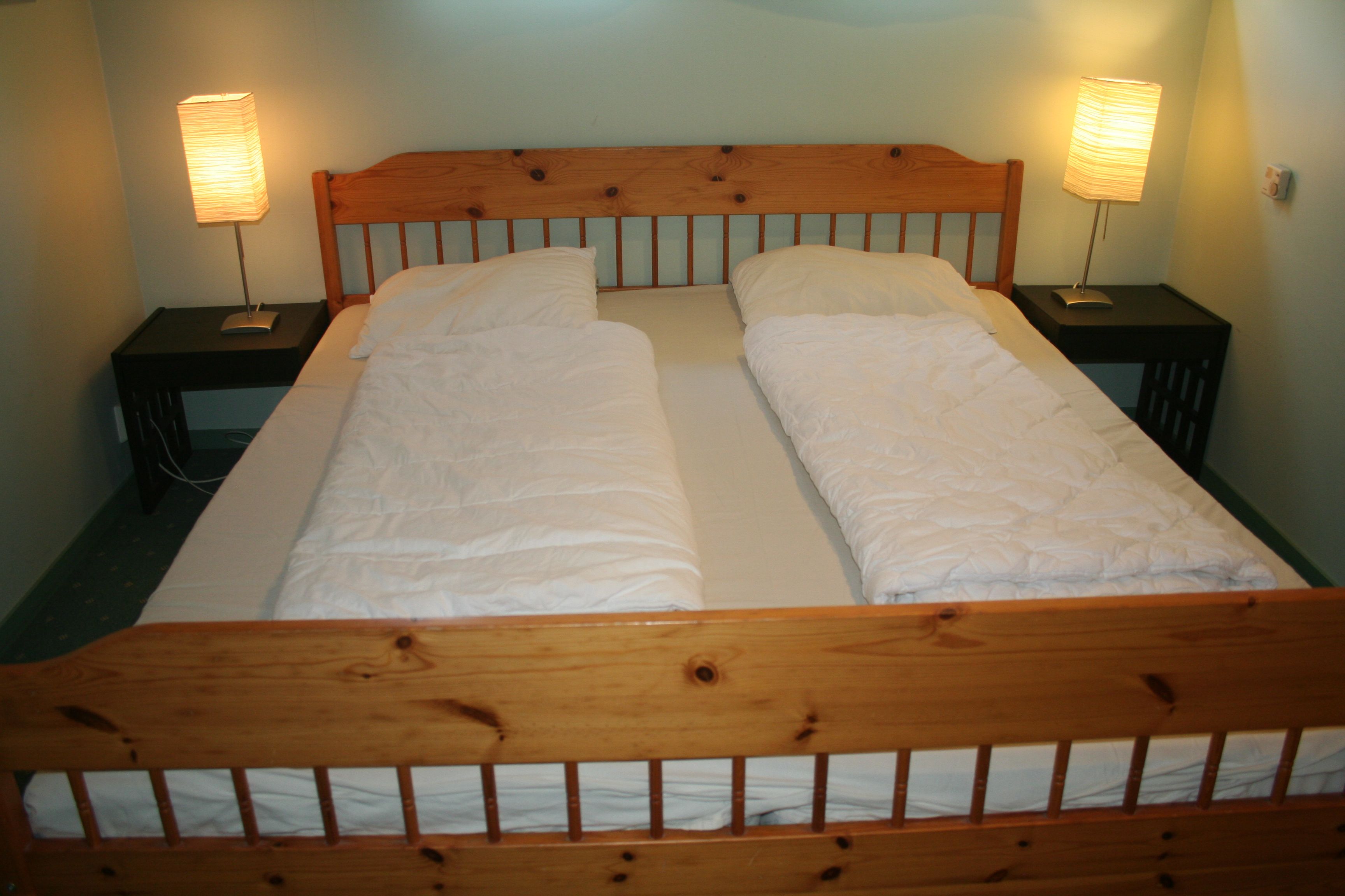 Bedroom with double bed and warm, simple interior at Hardanger Feriesenter.