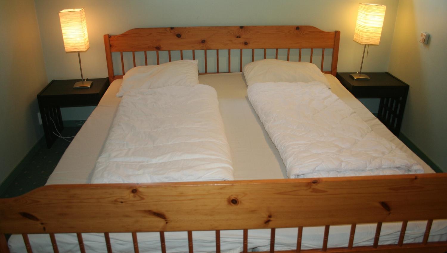 Bedroom with double bed and warm, simple interior at Hardanger Feriesenter.