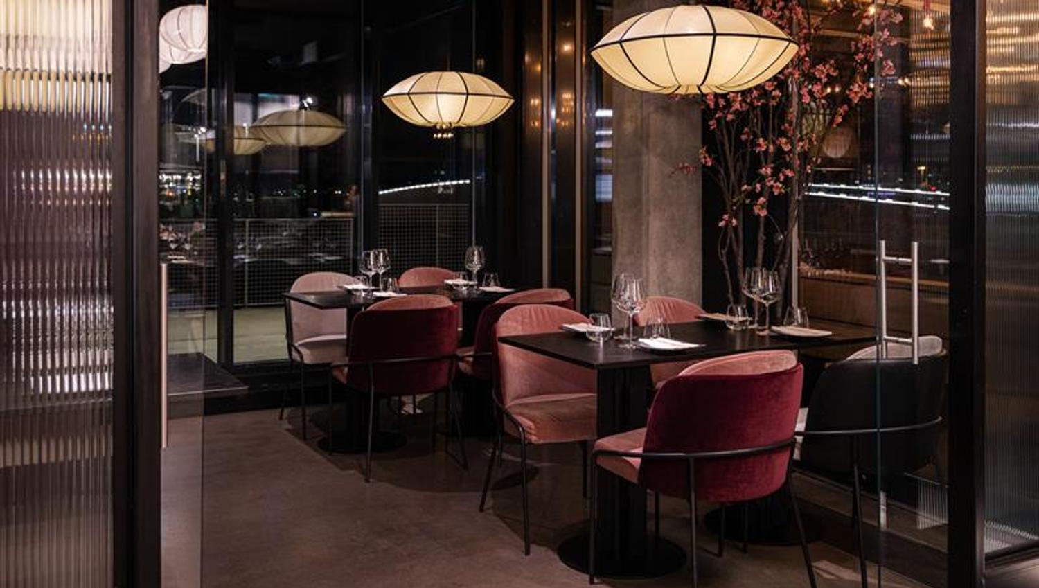 Small black tables and red chairs under ceiling lights