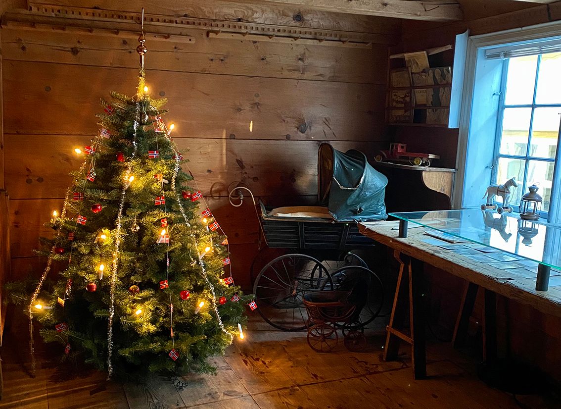 A decorated christmas tree and an old fashioned stroller 