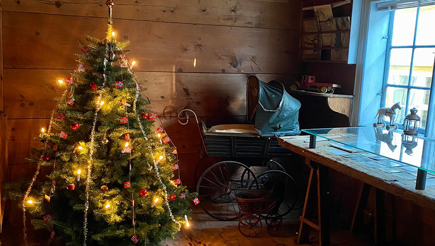 A decorated christmas tree and an old fashioned stroller