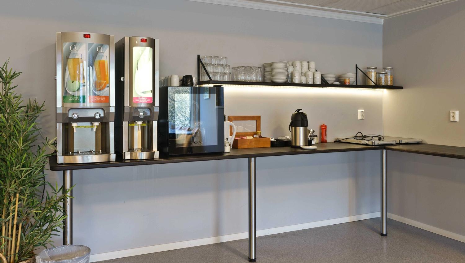 Breakfast area at Husnes Sentrum Hotel with juice dispensers, coffee and modern facilities.
