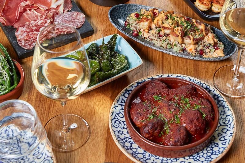 Detail photo of various tapas dishes on a wooden table.
