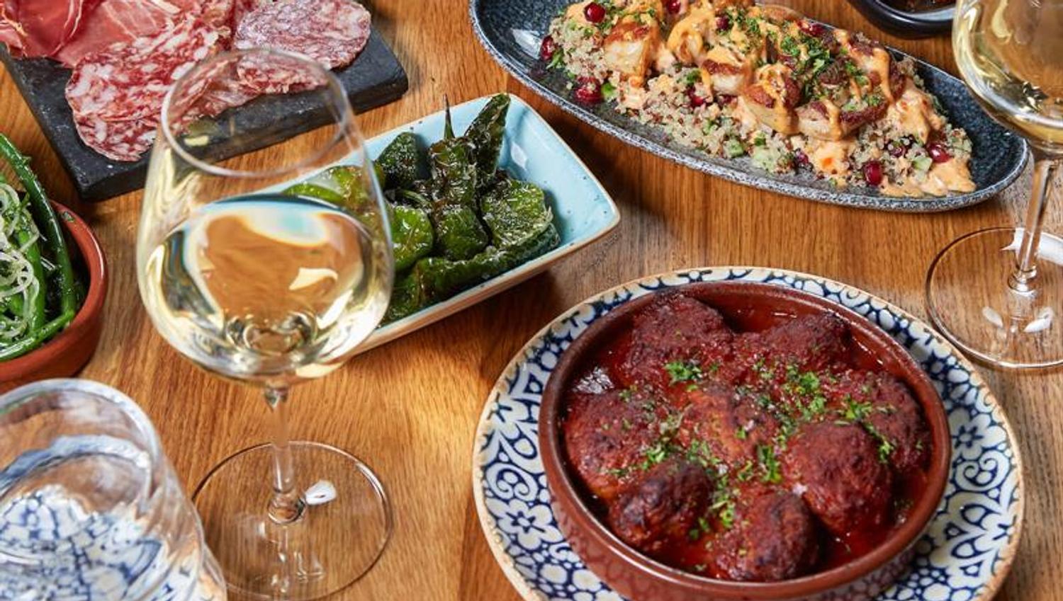 Detail photo of various tapas dishes on a wooden table.