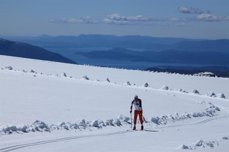 Langrennsløpar trenar på Folgefonna med panoramautsikt over fjord og fjell.