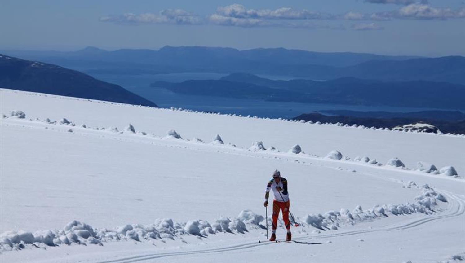 Langrennsløpar trenar på Folgefonna med panoramautsikt over fjord og fjell.