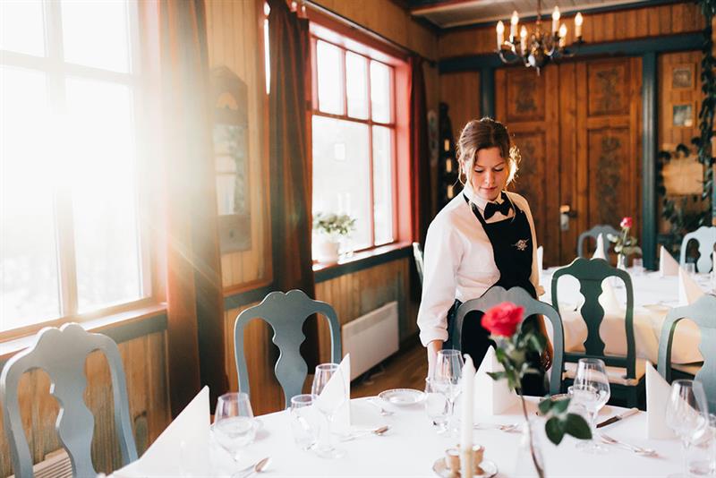waitress sets the table at the restaurant at Tuddal Høyfjellshotell