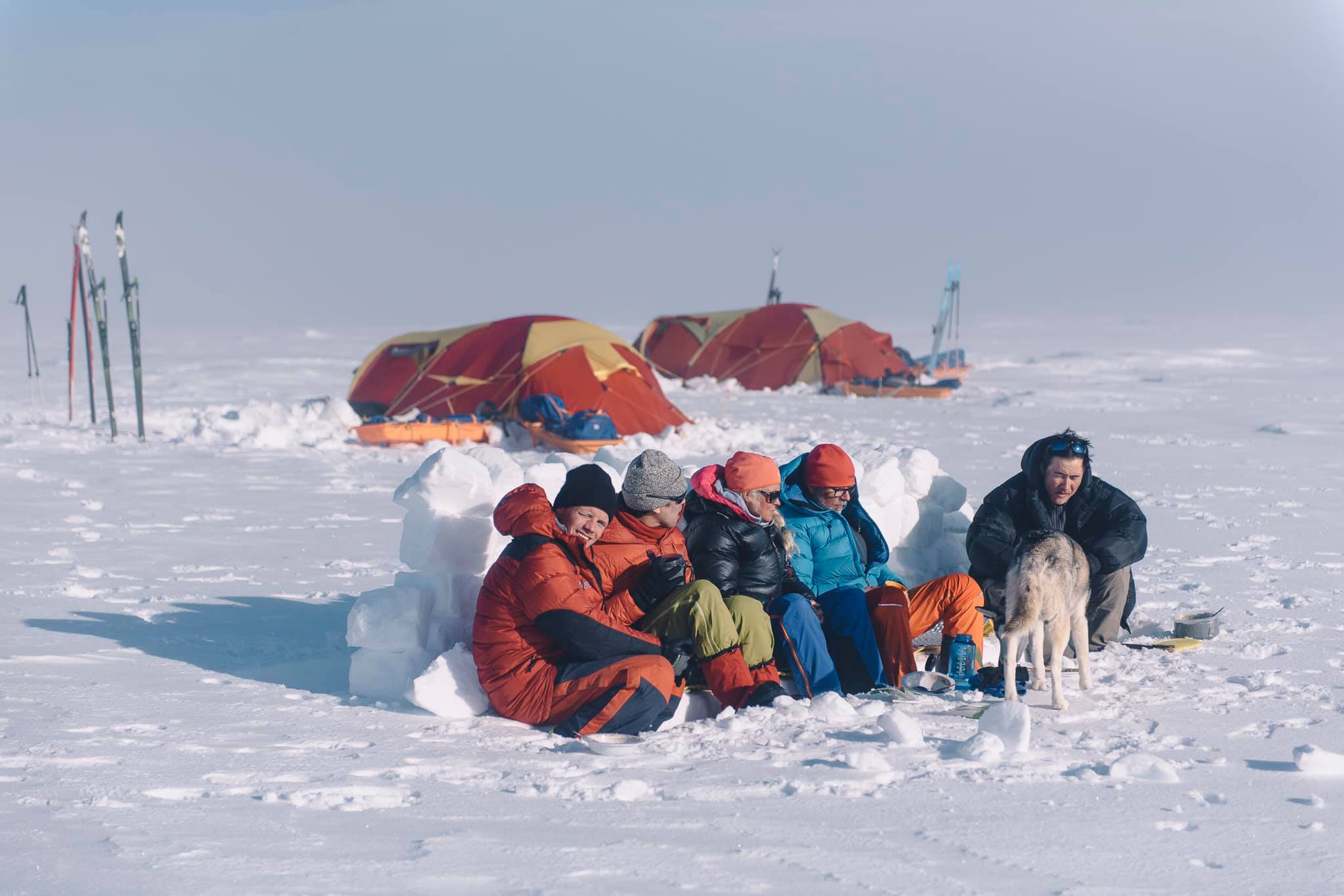 A tour group sitting huddled up together in a tent camp