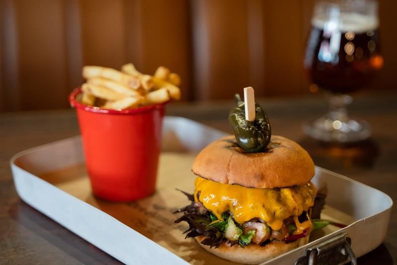 Detalj av cheeseburger, pommes frites og øl.