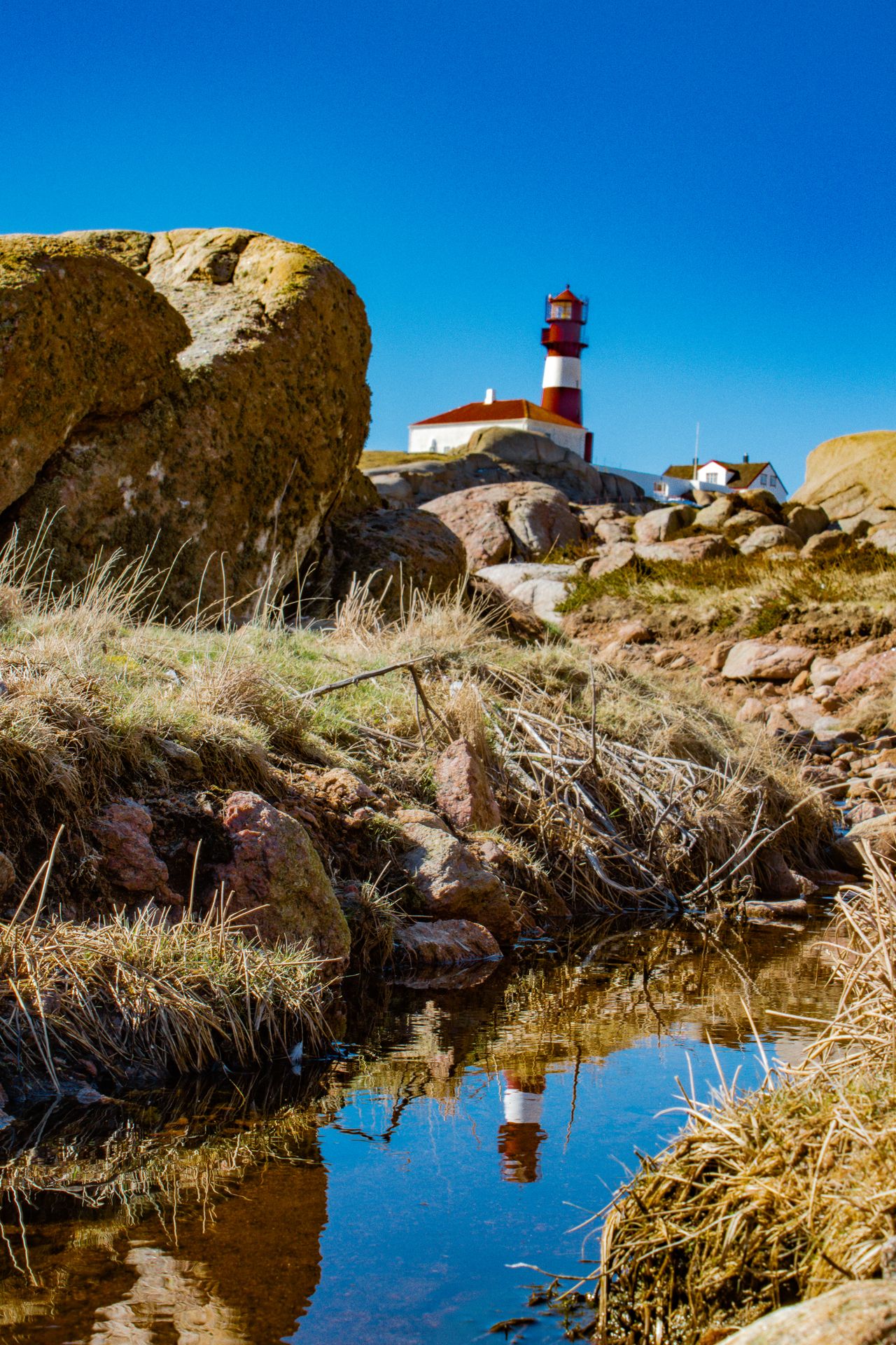 Ryvingen Lighthouse, reflected in a small puddle between rocks and stones