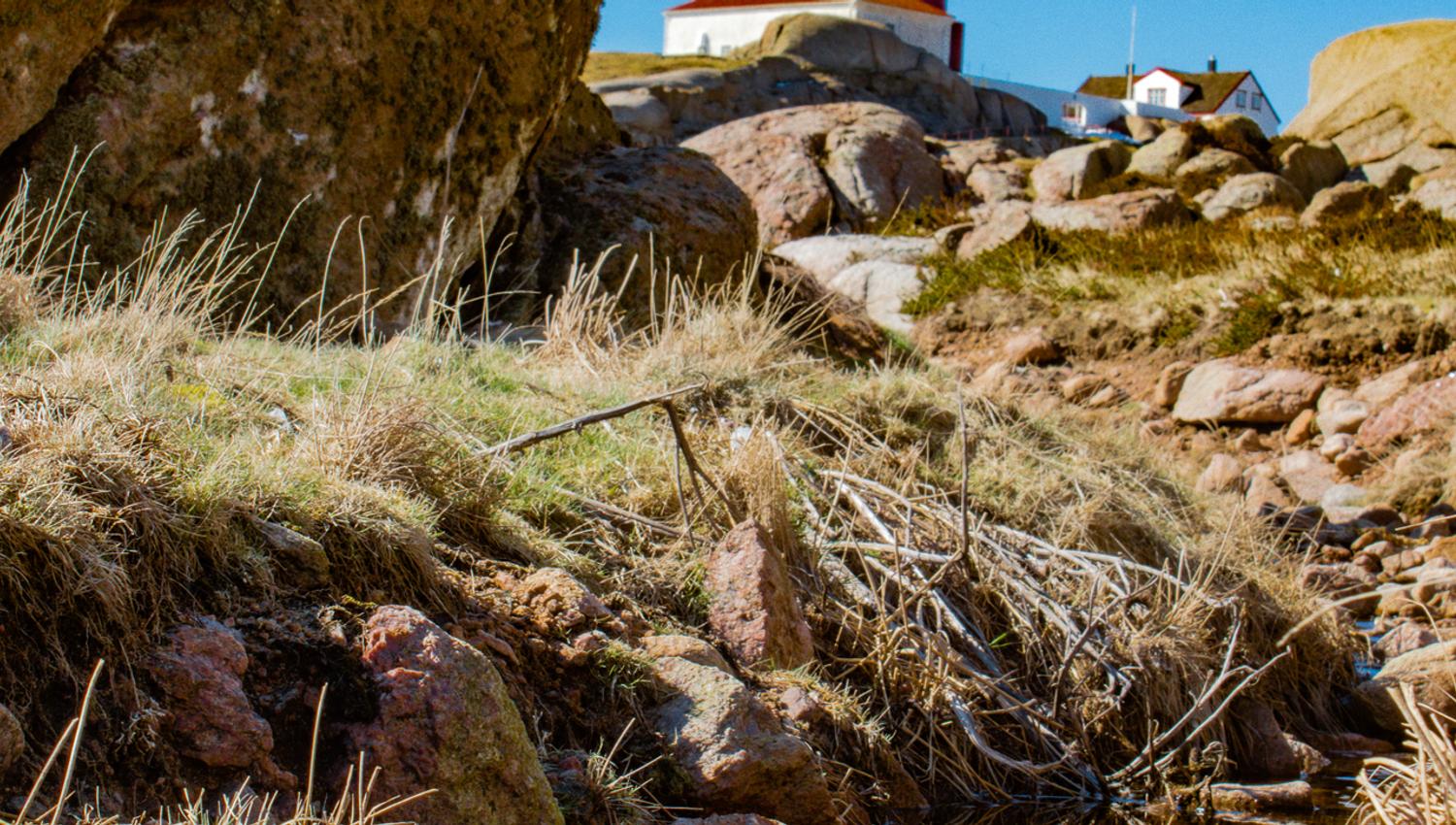 Ryvingen Lighthouse, reflected in a small puddle between rocks and stones