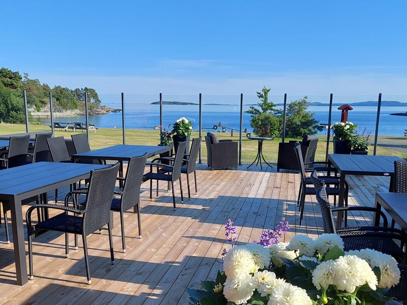 Terrace view with blue sea and sky, tables an chairs on deck