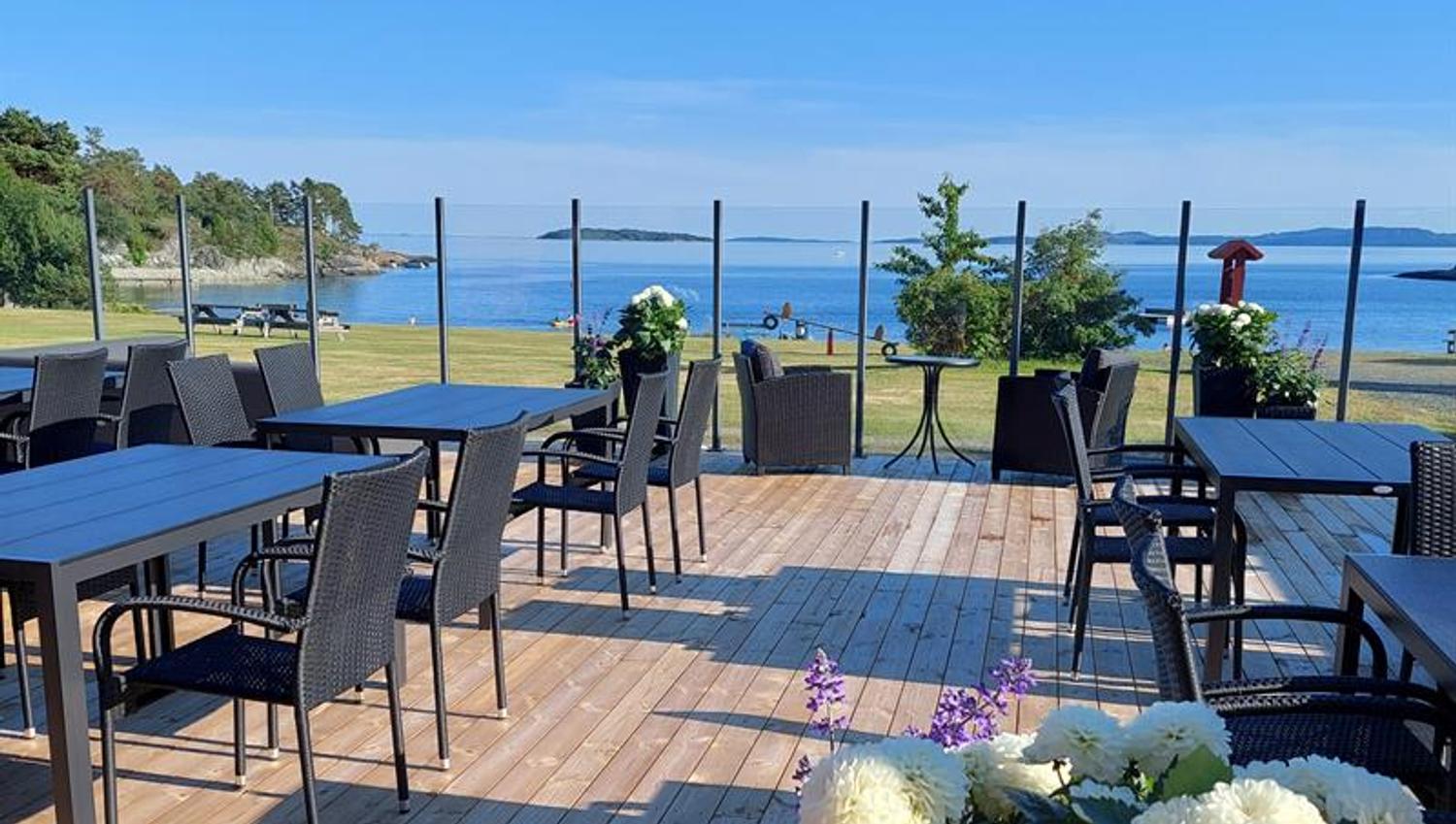 Terrace view with blue sea and sky, tables an chairs on deck