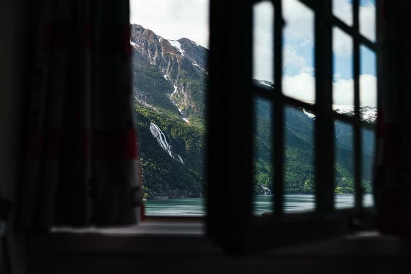 View from a room at Tyssedal Hotel in Hardanger, showcasing a stunning vista of fjords, mountains and waterfalls.