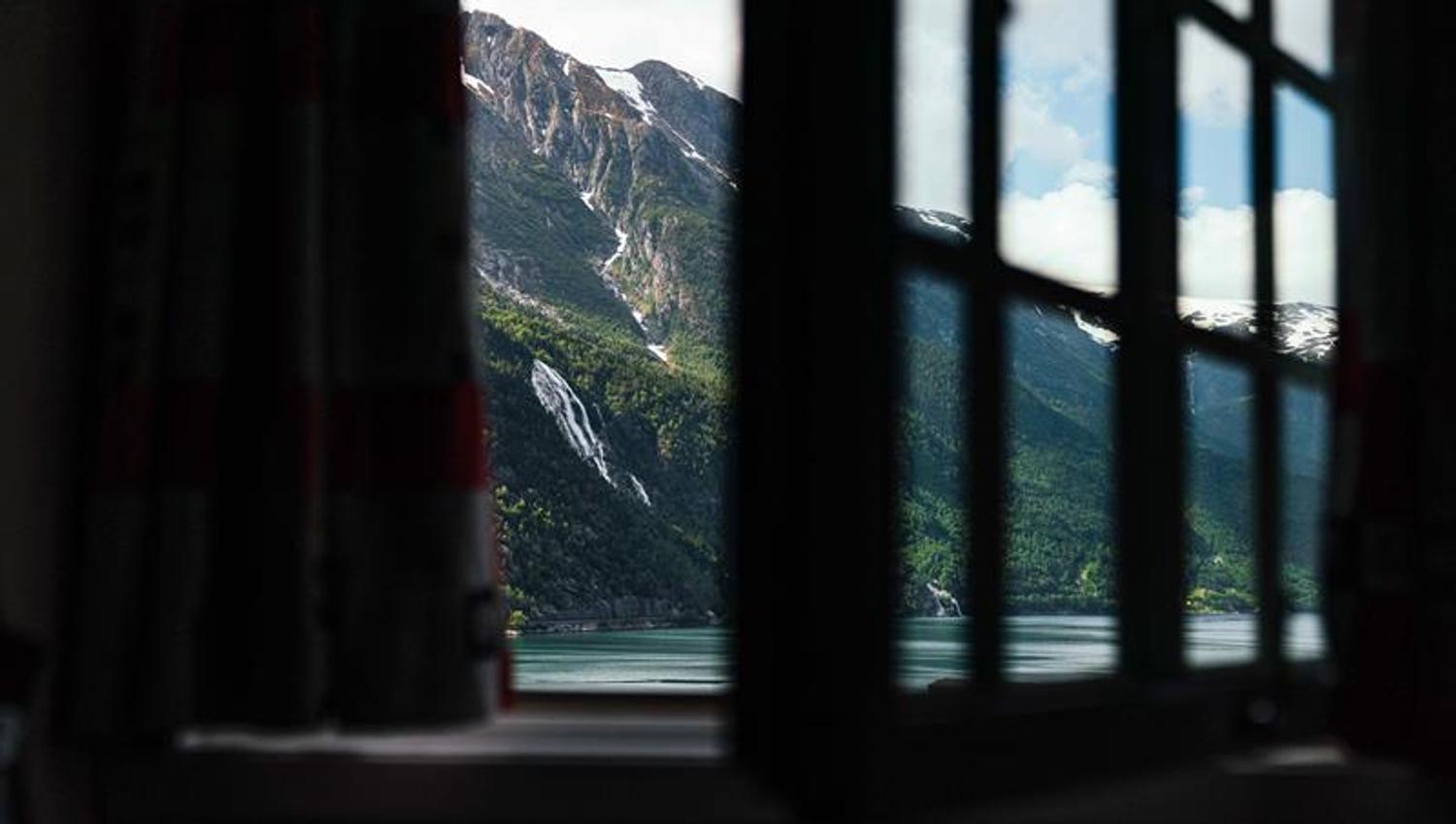 View from a room at Tyssedal Hotel in Hardanger, showcasing a stunning vista of fjords, mountains and waterfalls.