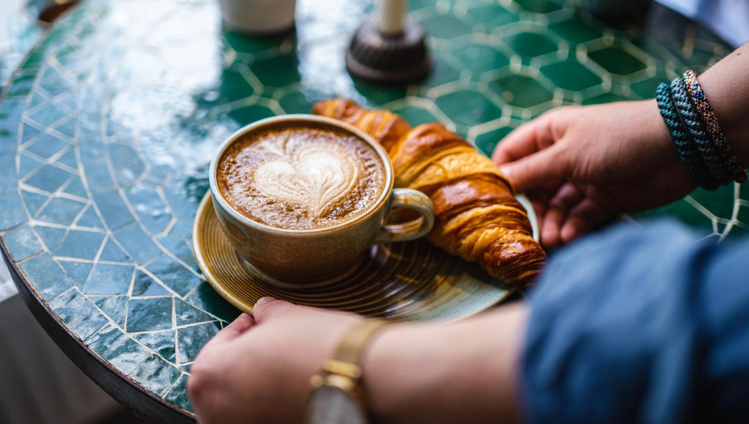 a tray with coffee and a croissant