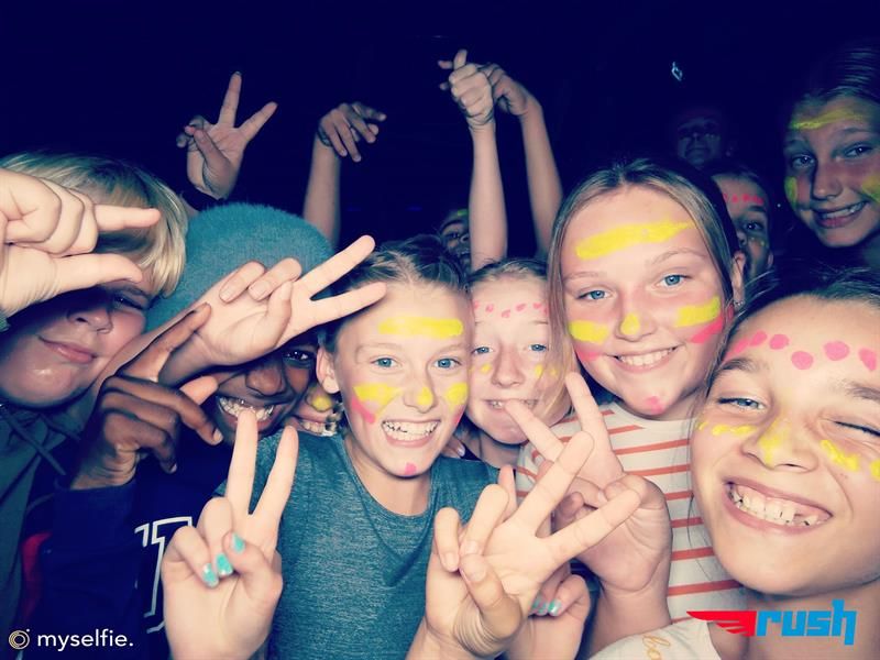 Children with face paint smile at the camera