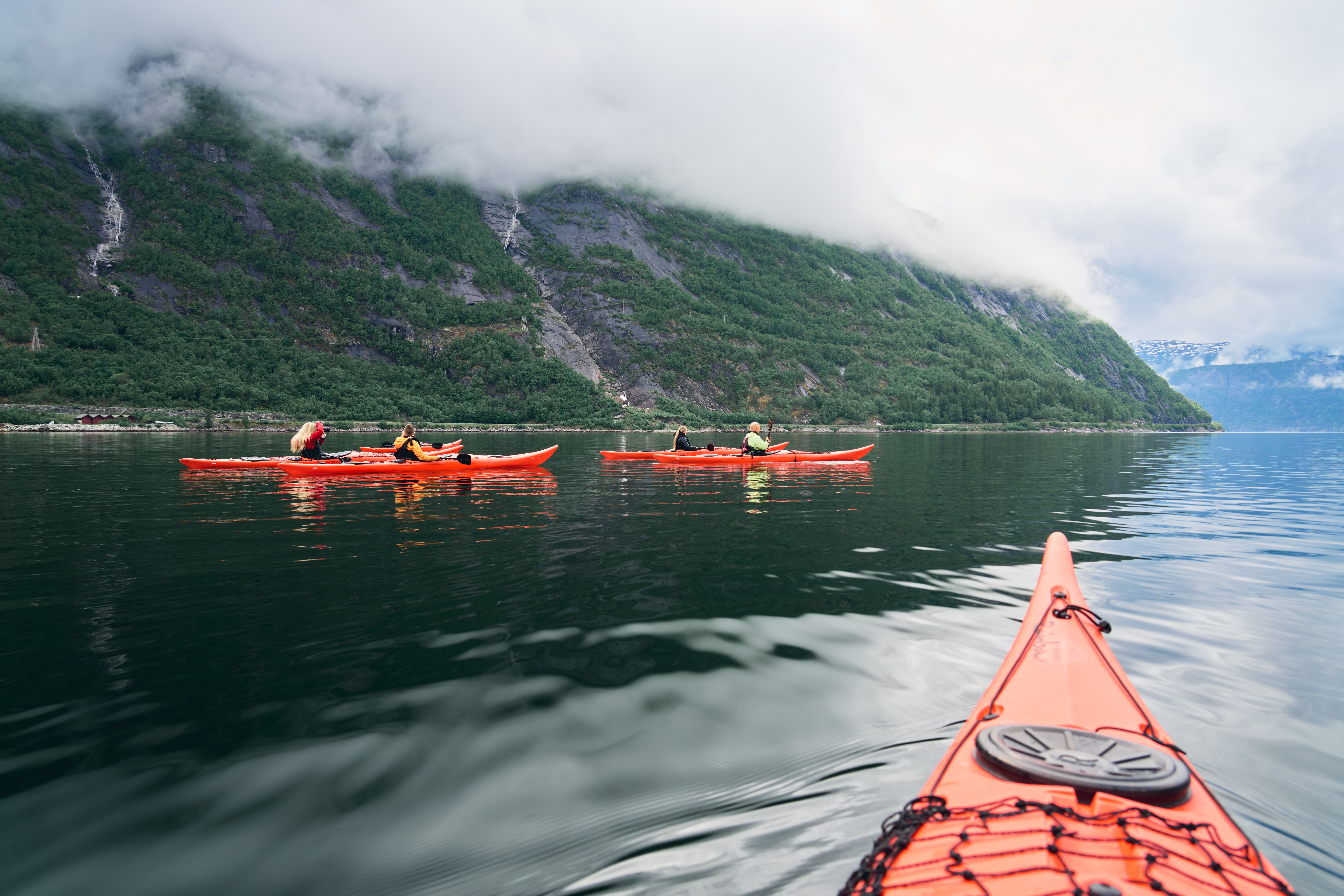 Noen røde kajakker på fjorden.