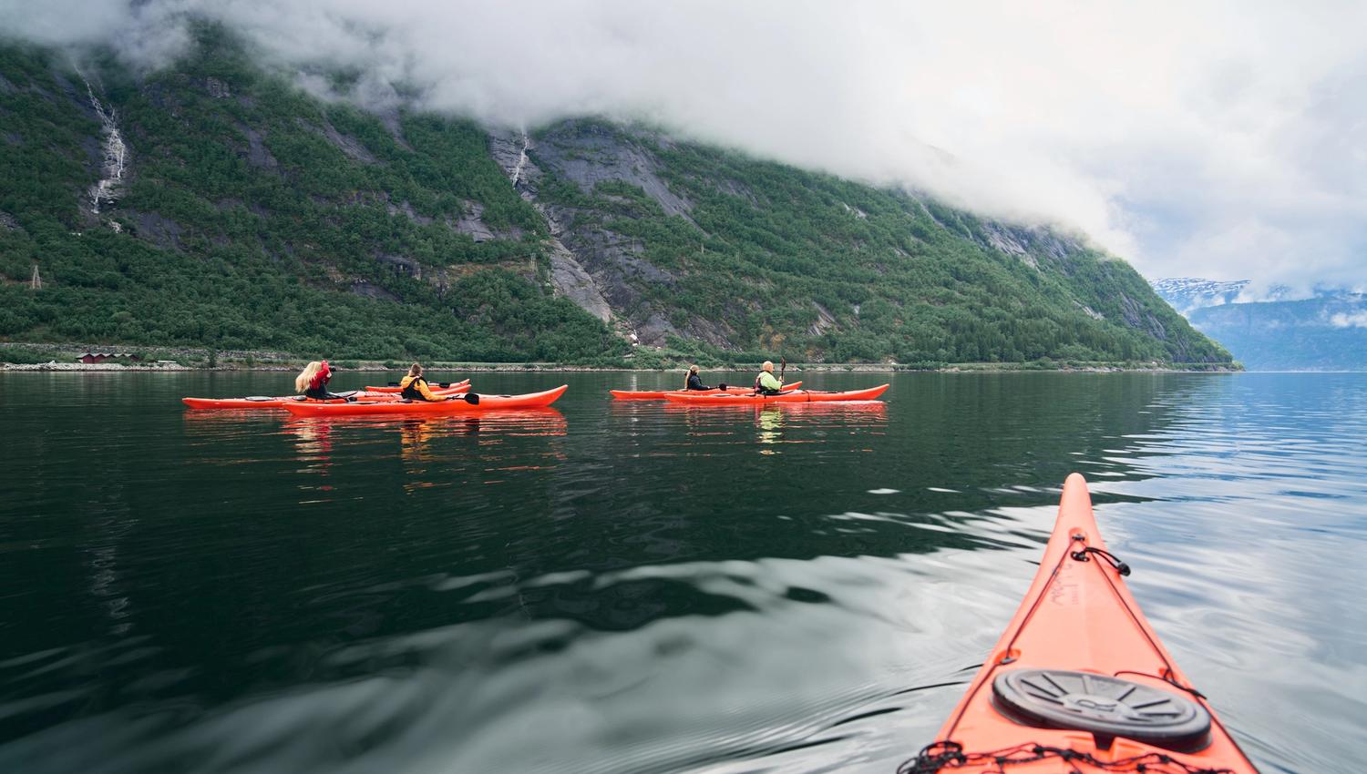 Noen røde kajakker på fjorden.