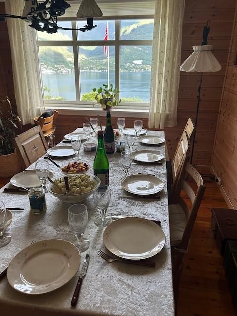 A set table in a cozy dining room with views of the Hardangerfjord at Jaastad Gjestetun. Ideal for intimate meals.
