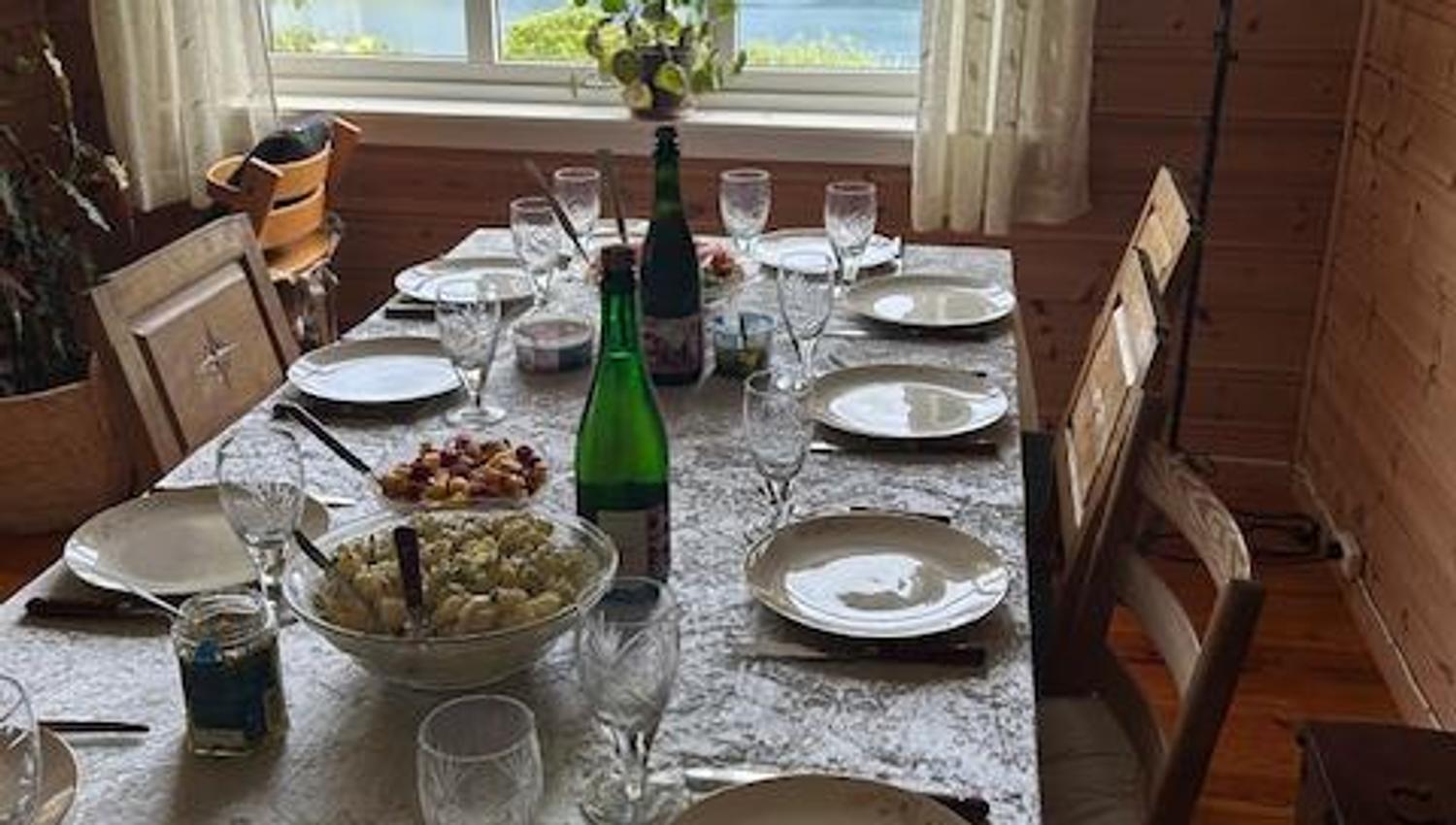 A set table in a cozy dining room with views of the Hardangerfjord at Jaastad Gjestetun. Ideal for intimate meals.