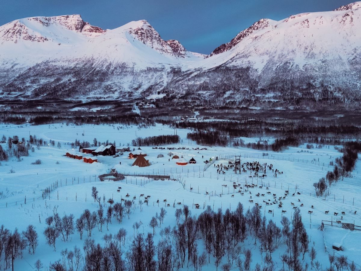 Tromsø Lapland’s reindeer camp surrounded by snow-covered mountains and Arctic winter scenery near Tromsø.
