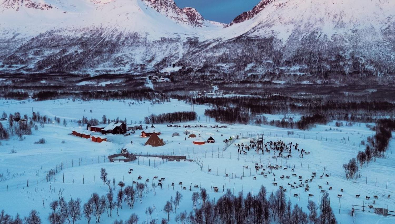 Tromsø Lapland’s reindeer camp surrounded by snow-covered mountains and Arctic winter scenery near Tromsø.