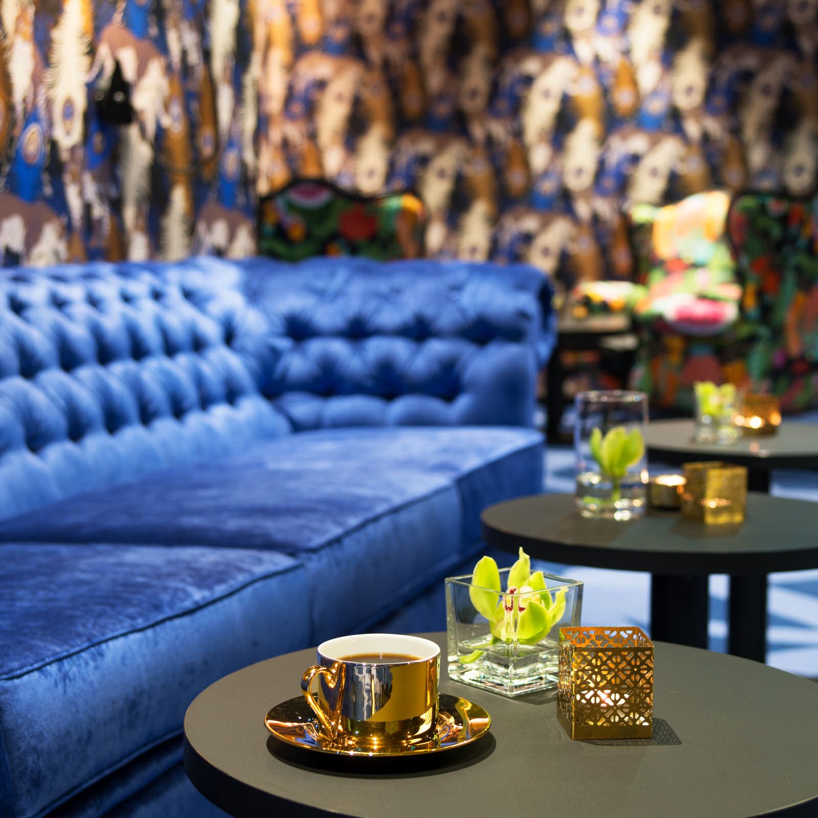 Blå sofa og kaffekopp i messing. Lounge på Thon Hotel Terminus i Oslo. Foto.