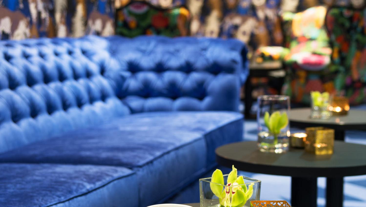 Blå sofa og kaffekopp i messing. Lounge på Thon Hotel Terminus i Oslo. Foto.