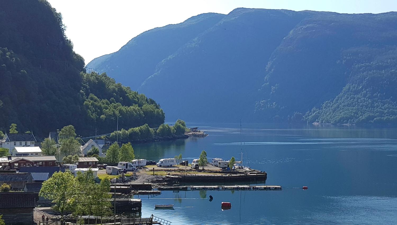 Campingplassen sett frå vegen med fjord, natur og campingliv i Hardanger.