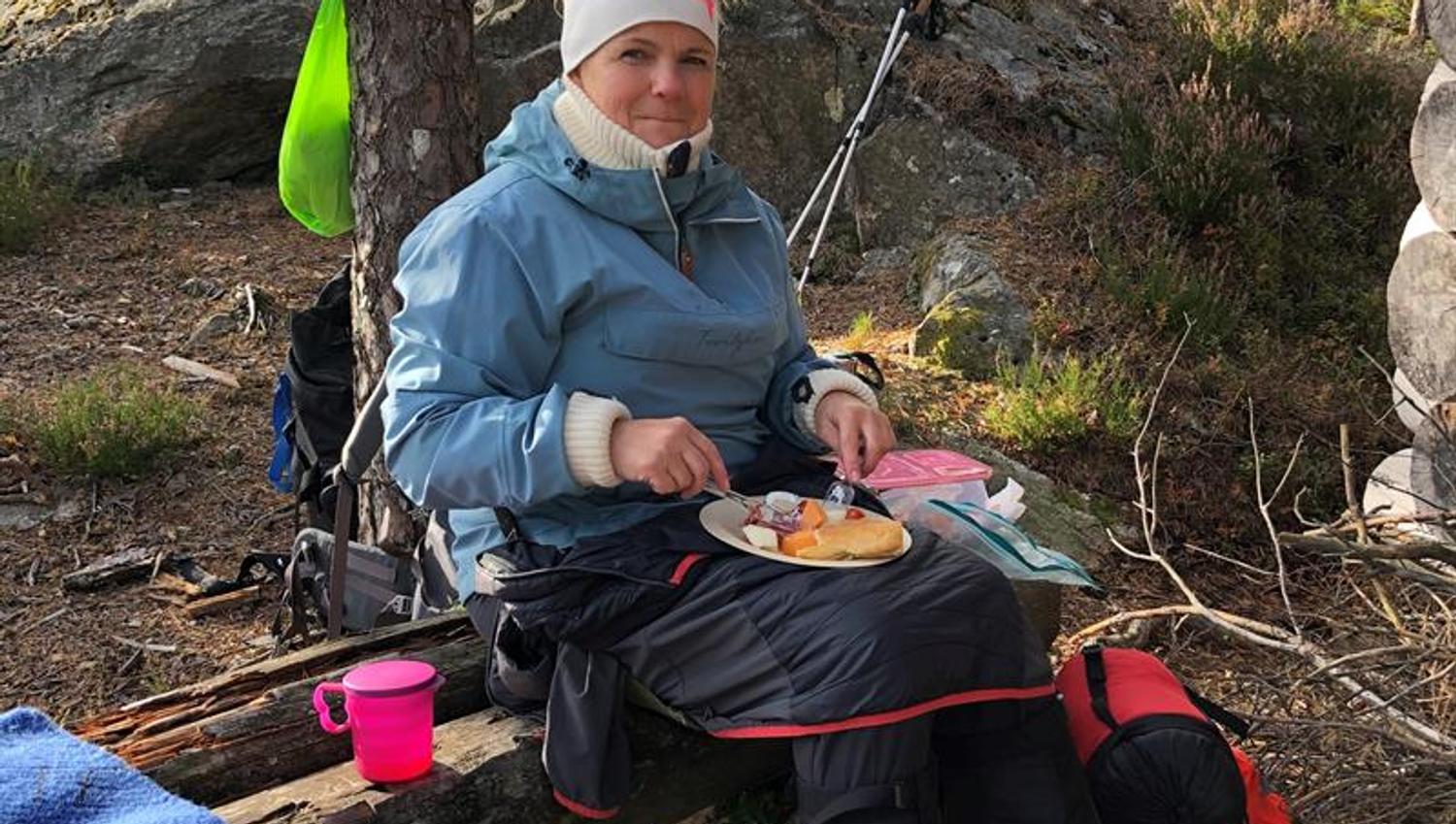 Dame som spiser mat i skogen