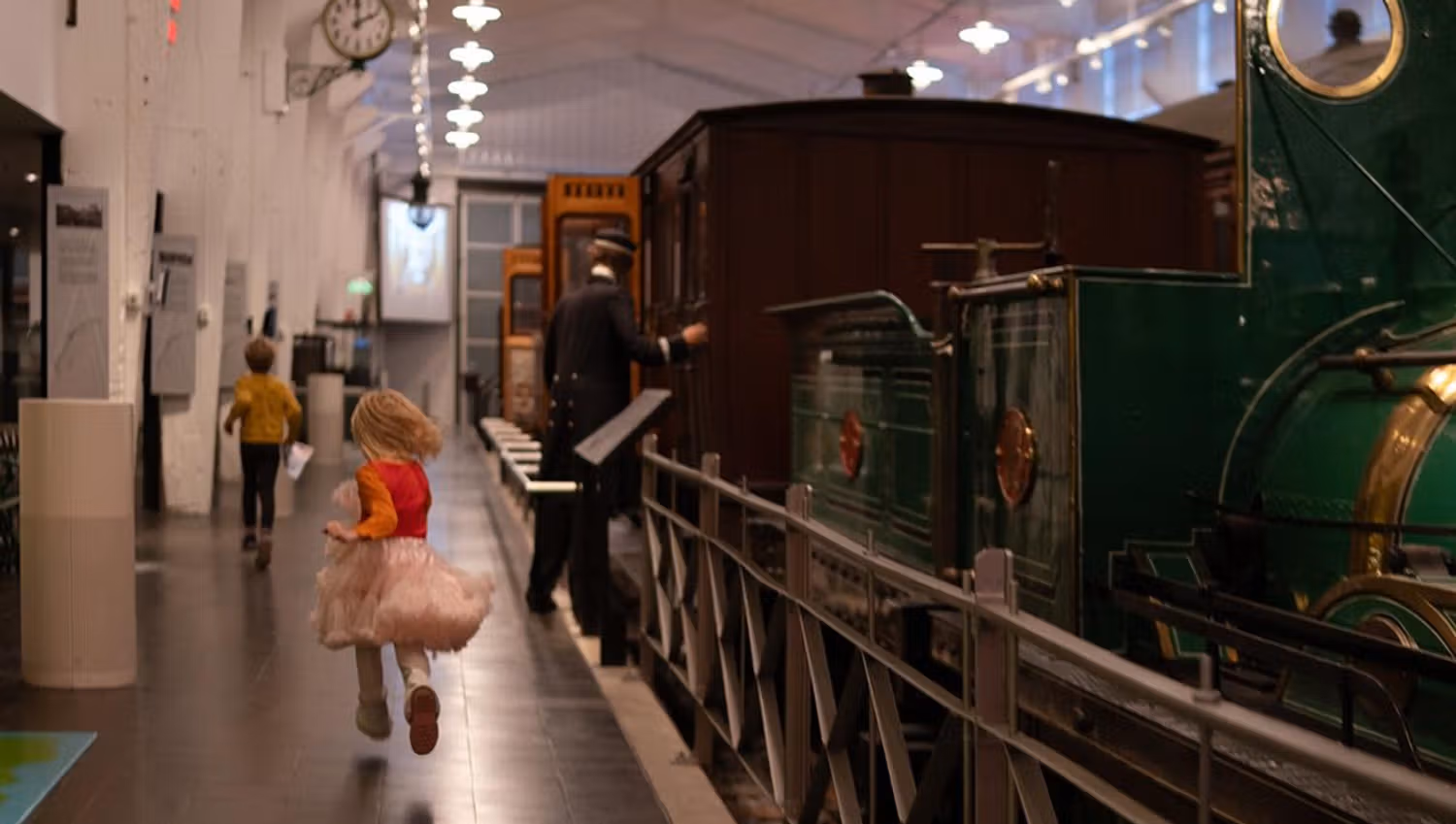 Museum hall with trains and a person walking along the exhibition.