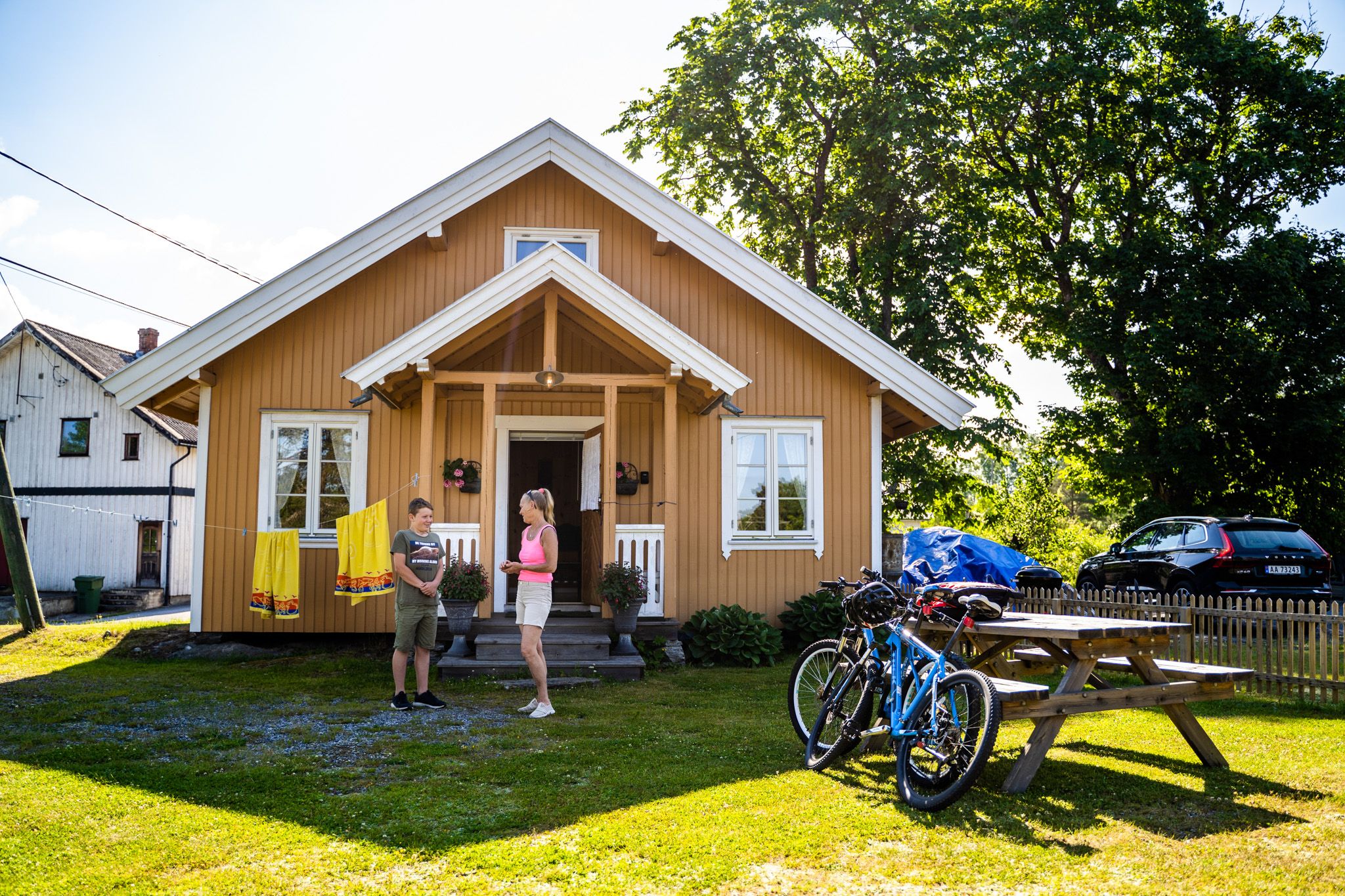 Folk og sykler foran hus