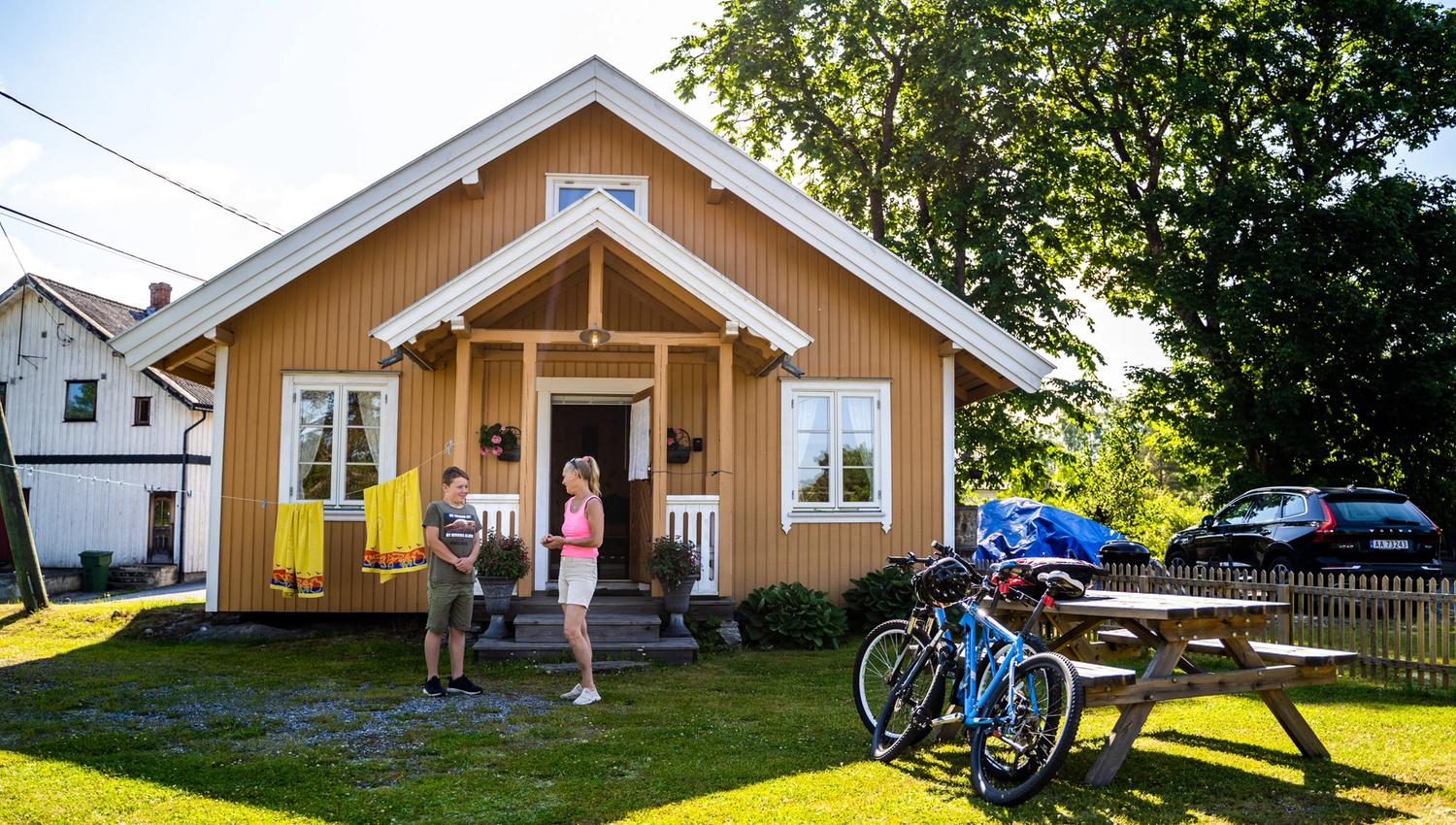 Folk og sykler foran hus