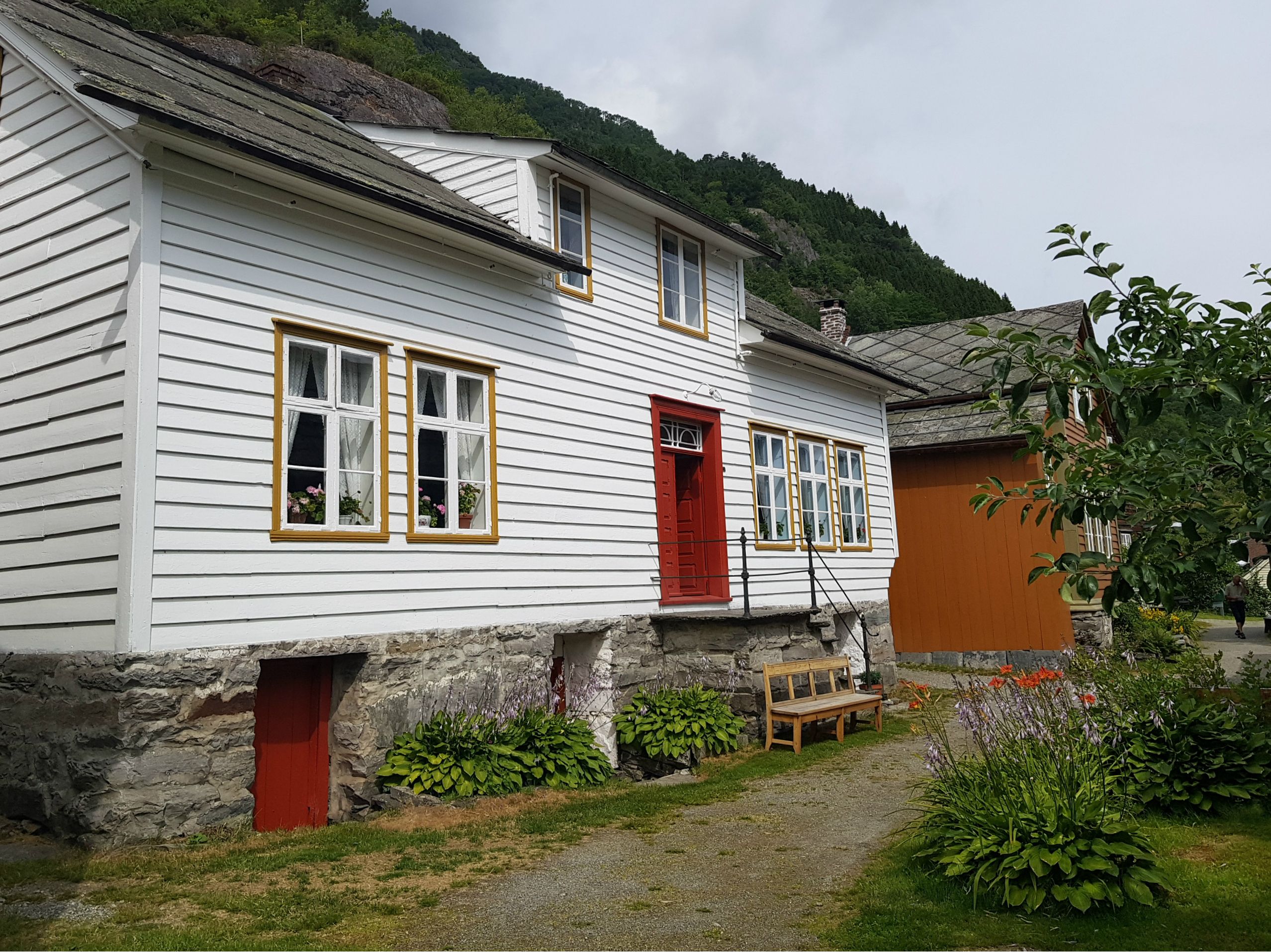 one white and one orange house with a bench outside 