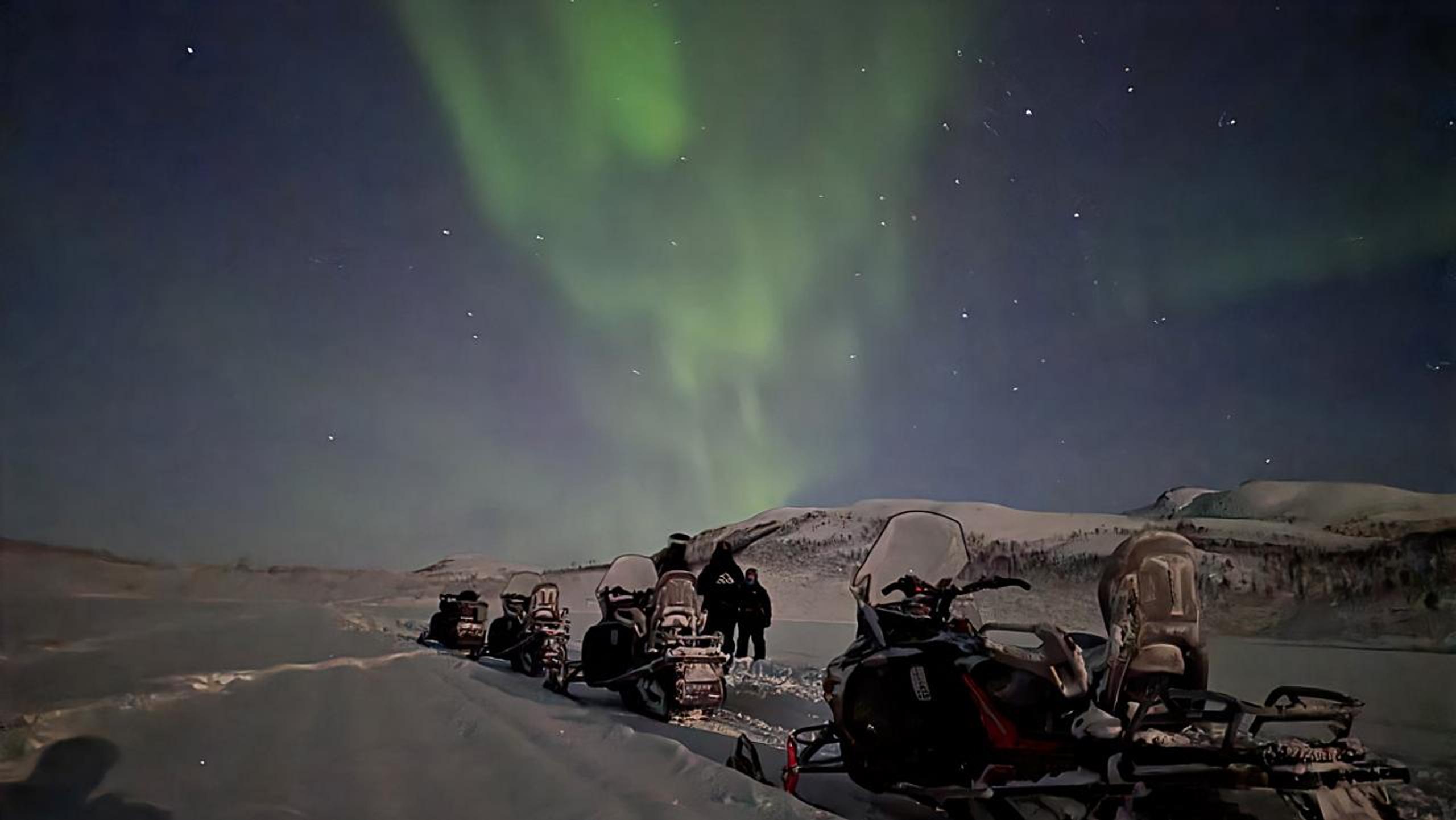 Northern lights hunt with snowmobile