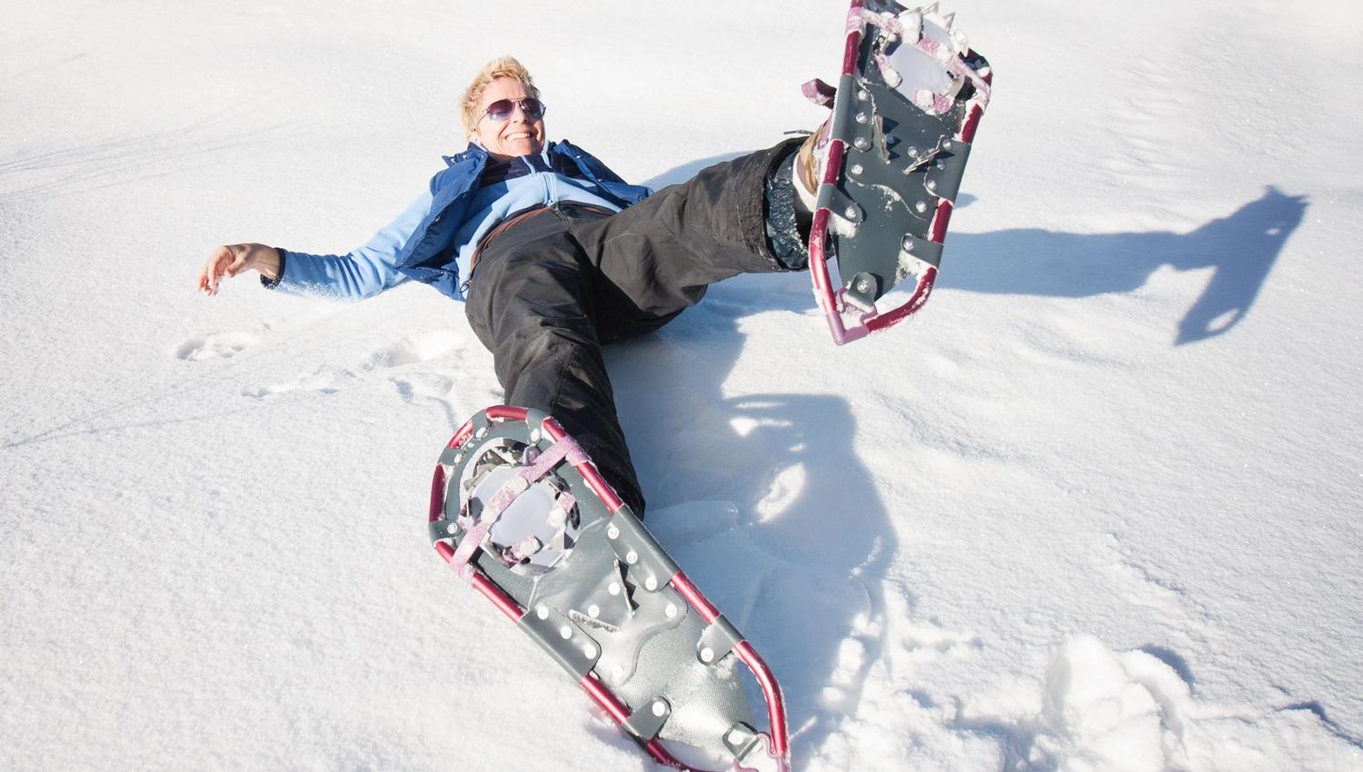 Person fallen down on the snow wearing snowshoes