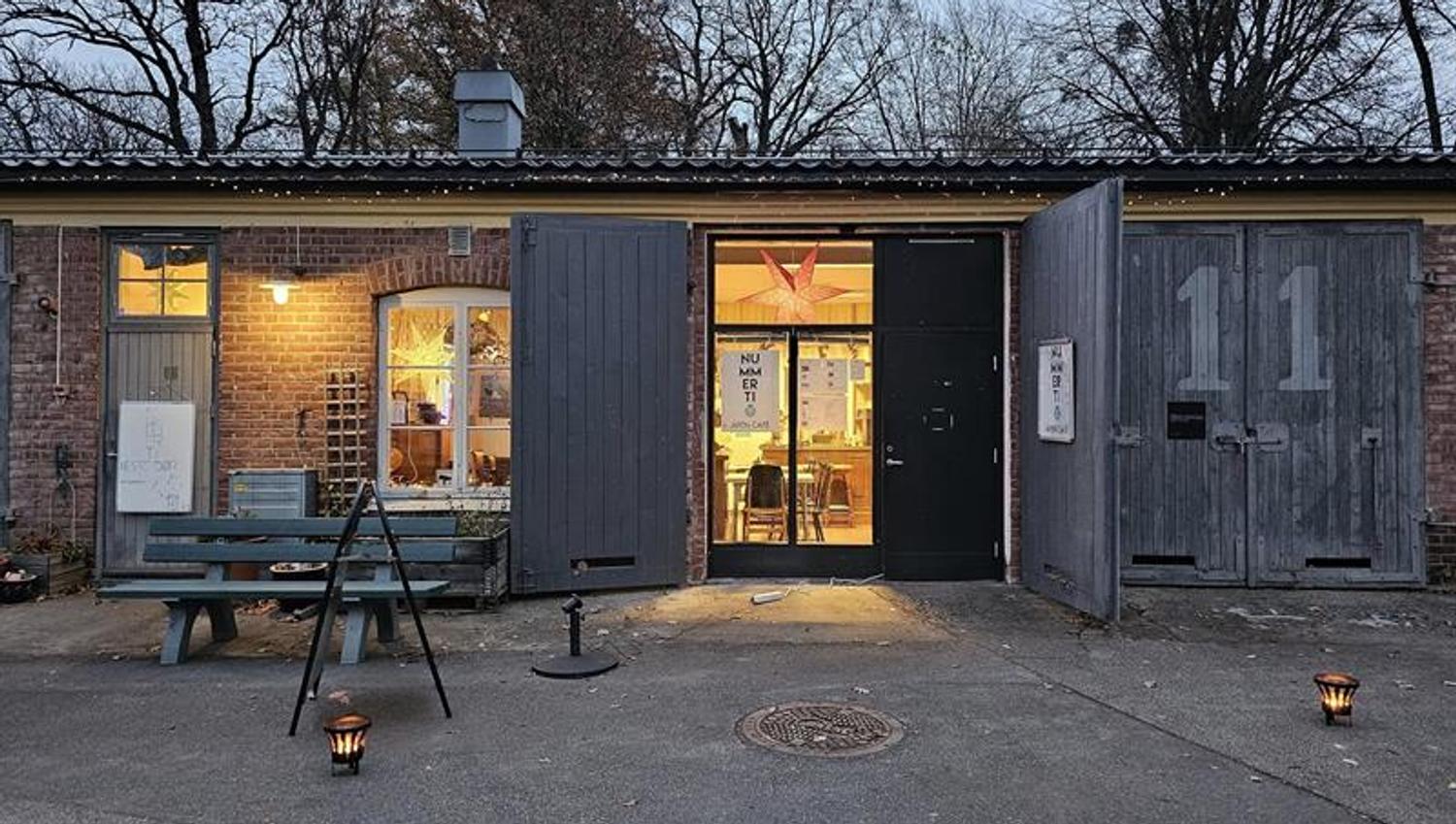 Inngangen til Nummer Ti i en historisk mursteinsbygning på Karljohansvern, med lys fra vinduene.