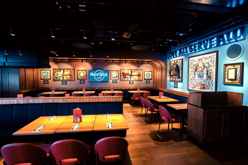Small square tables with red chairs and various pieces of rock memorabilia on the walls