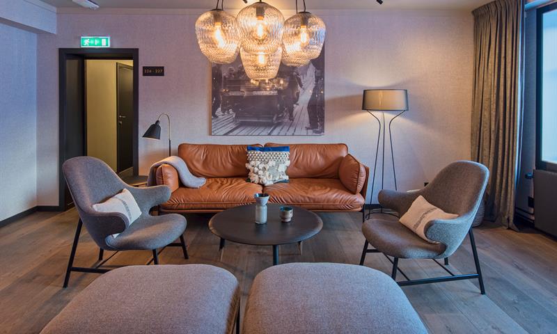 A sofa and chairs around a coffee table in a lounge