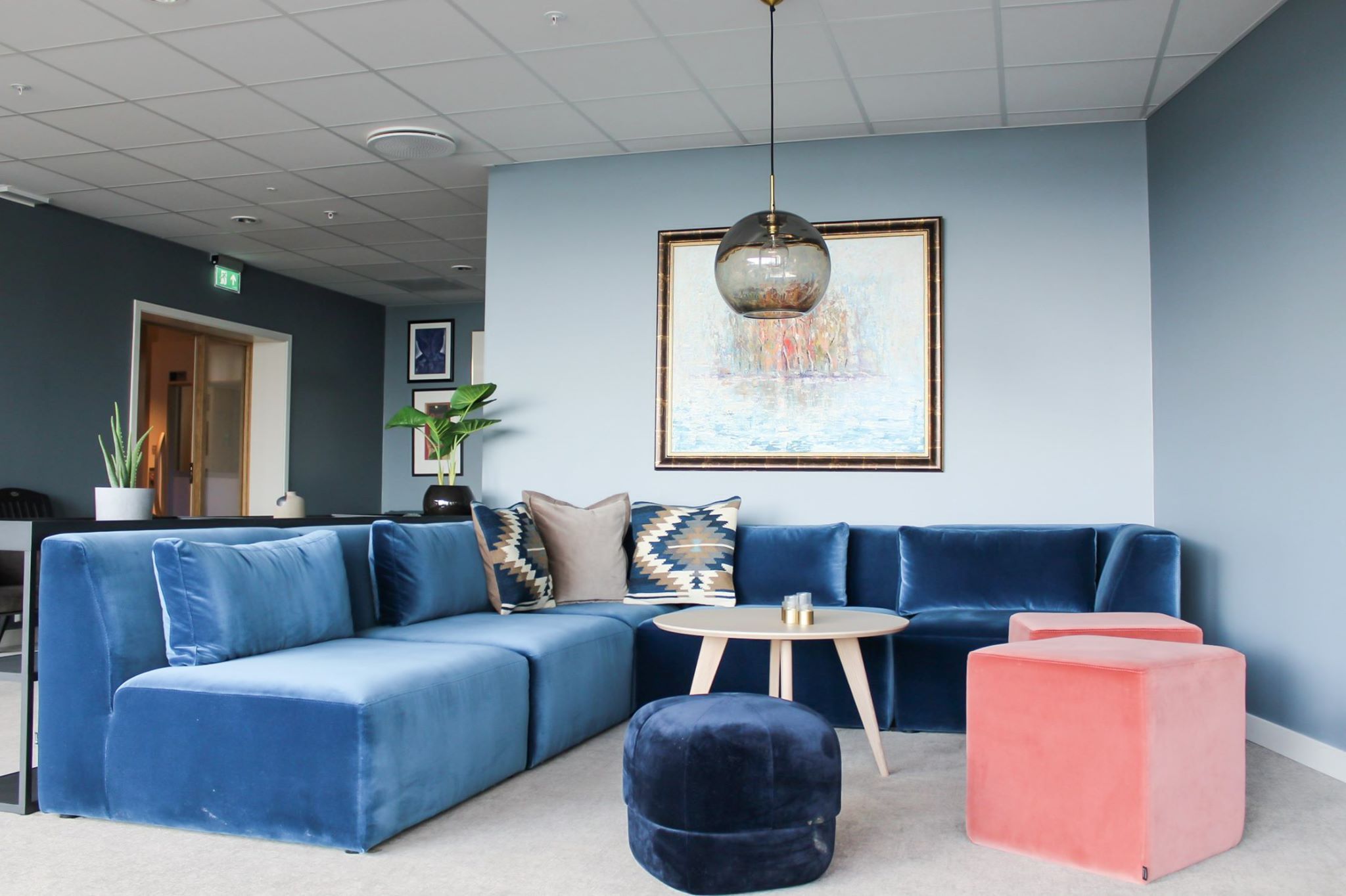Cozy blue sofa with decorative cushions in a stylish lounge setting.